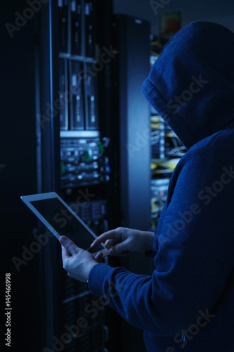 The hacker uses a tablet computer to steal information.
