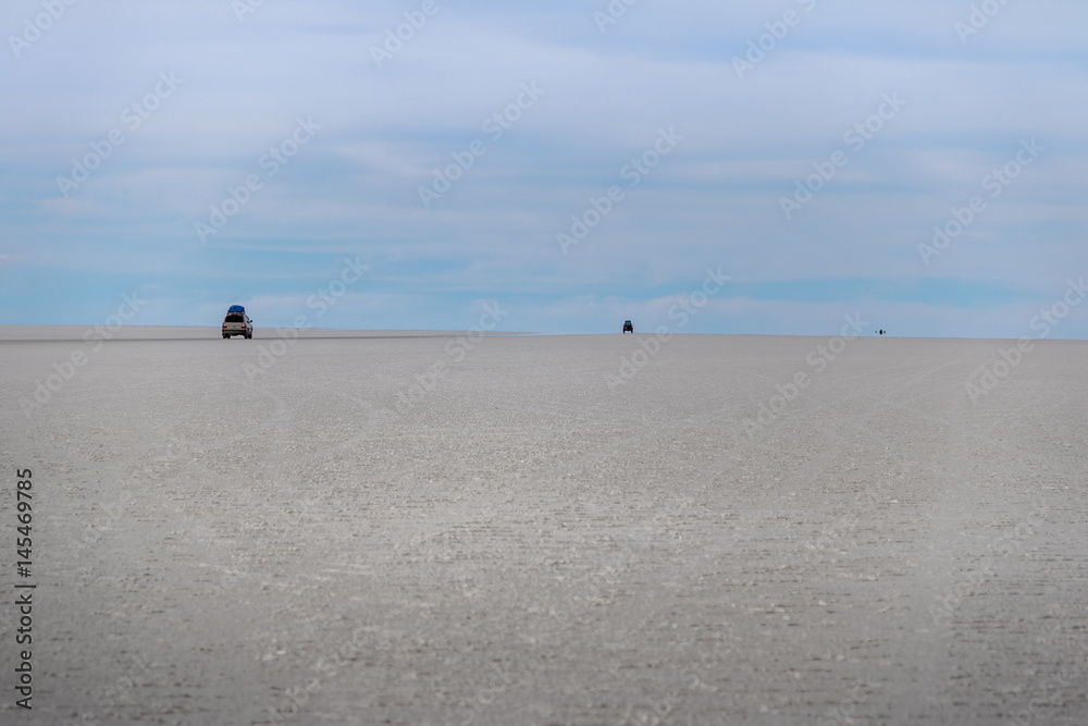 Cars disappearing into horizon in Salar de Uyuni salt flat - Potosi Department, Bolivia Cars disappearing into horizon in Salar de Uyuni salt flat - Potosi Department, Bolivia