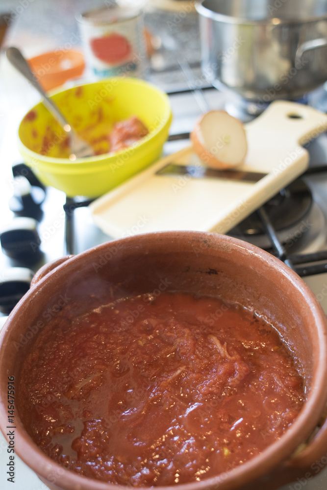 preparing tomato sauce in earthenware saucepan preparing tomato sauce in earthenware saucepan