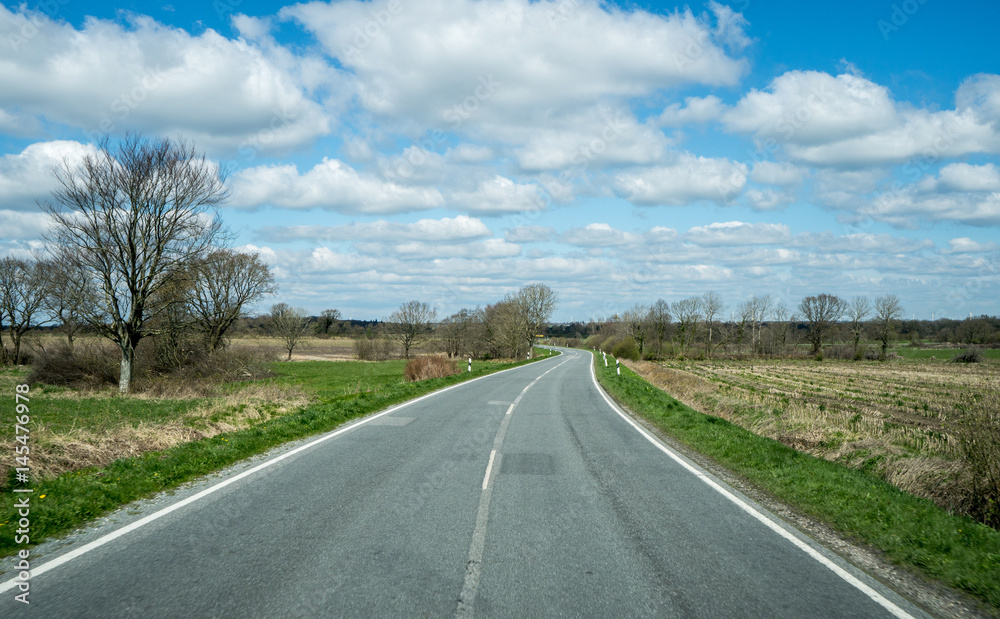 Fototapeta premium blauer Himmel mit wolken auf einer Nebenstrasse