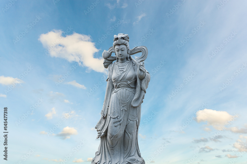 Guan Yin statue stone god of china on sky background. Guan Yin statue stone god of china on sky background.