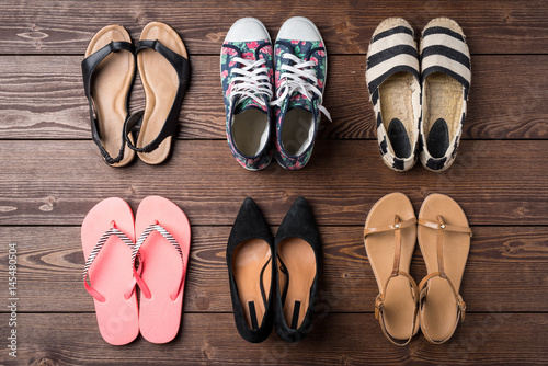 Collection of women's shoes on wooden background