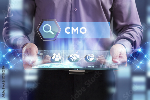 Business, Technology, Internet and network concept. Young businessman working on a virtual screen of the future and sees the inscription: CMO