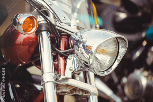 chrome classic motorcycle headlight and turn signals, soft toning of a warm color for the calendar © lanarusfoto