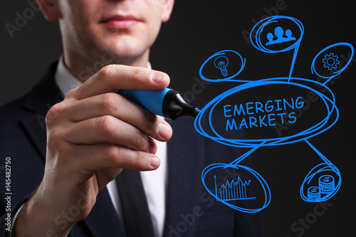 Business, Technology, Internet and network concept. Young business man writing word: Emerging markets