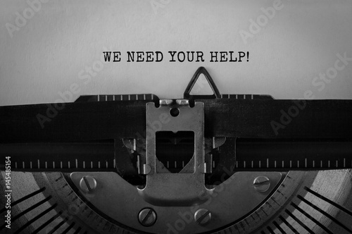 Text We Need Your Help typed on retro typewriter