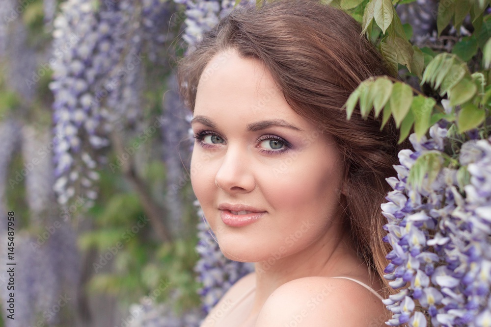 Wisteria. Portrait of a young beautiful woman near lilac flowers. Warm spring. Wisteria. Portrait of a young beautiful woman near lilac flowers. Warm spring.