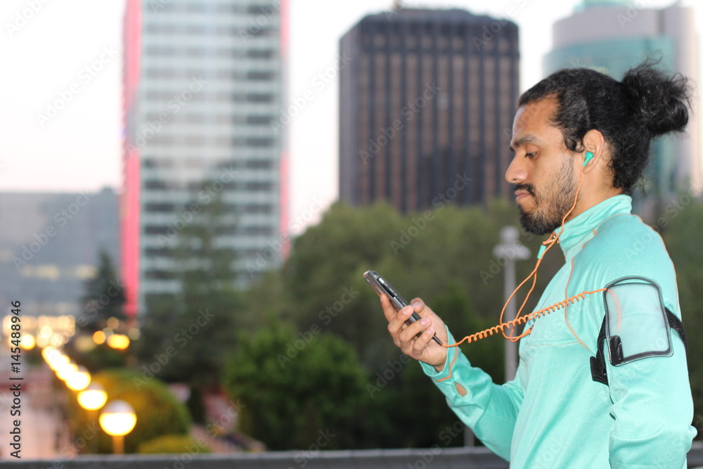 Male runner plays with smart phone before run in the city - Stock image Male runner plays with smart phone before run in the city - Stock image
