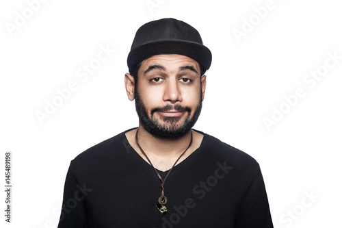 Portrait of young sad unhappy man with black t-shirt and cap looking at camera. studio shot, isolated on white background. © khosrork