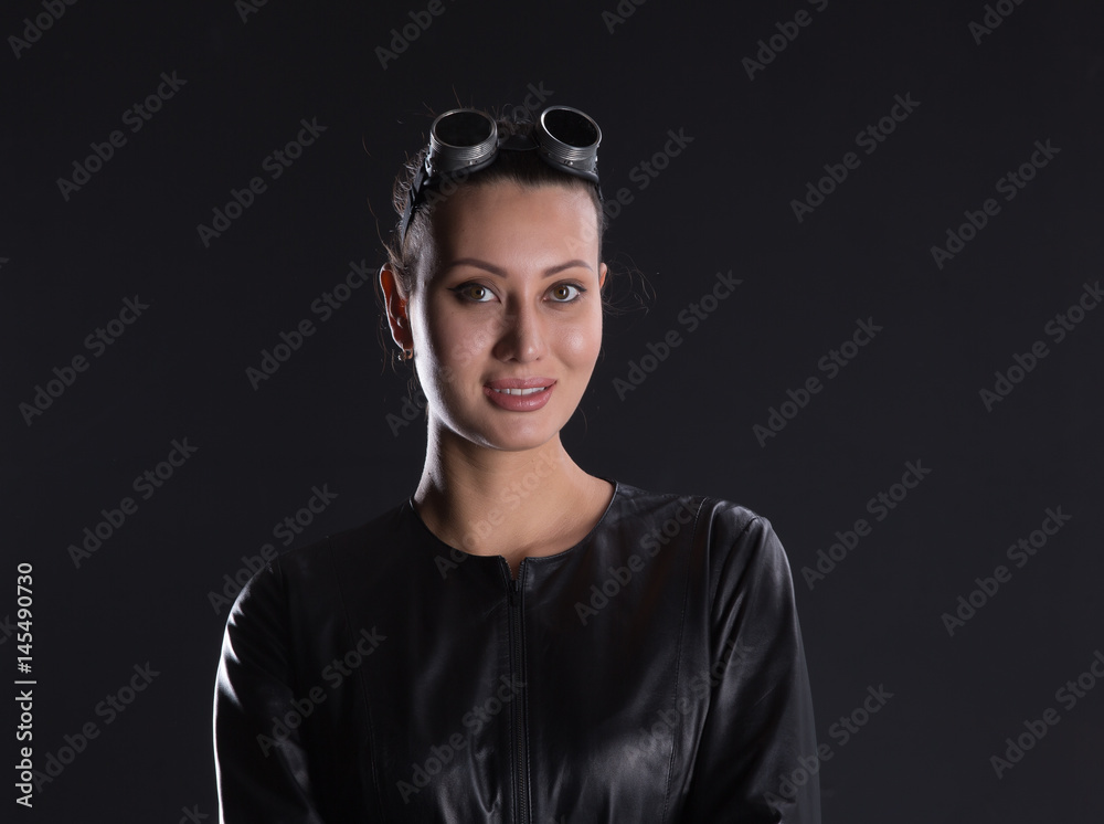 Beautiful girl in motorcycle goggles and a black leather jacket Beautiful girl in motorcycle goggles and a black leather jacket