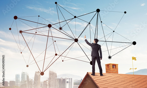Businessman on house roof presenting networking and connection c