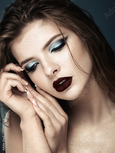 Attractive young model with blue make-up and manicure