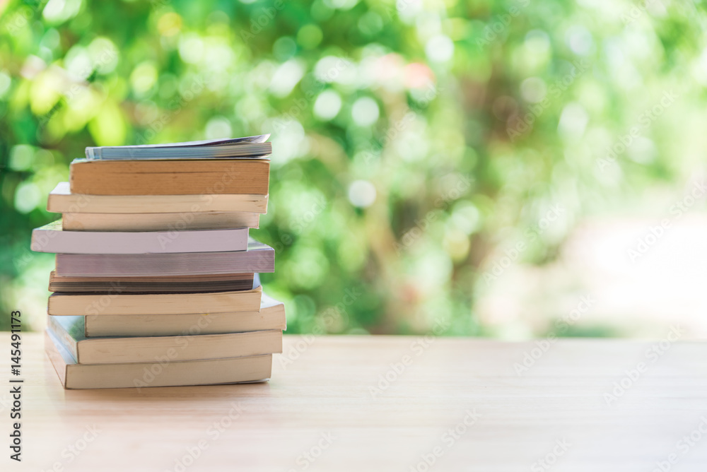 Book stack on wooden table with blur background Book stack on wooden table with blur background