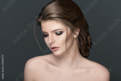 Studio portrait of a beautiful young woman with brown hair.