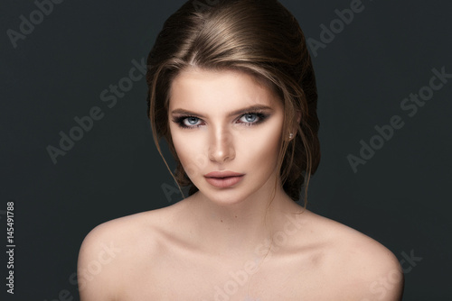 Studio portrait of a beautiful young woman with brown hair.