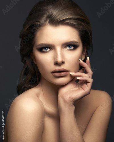 Studio portrait of a beautiful young woman with brown hair.