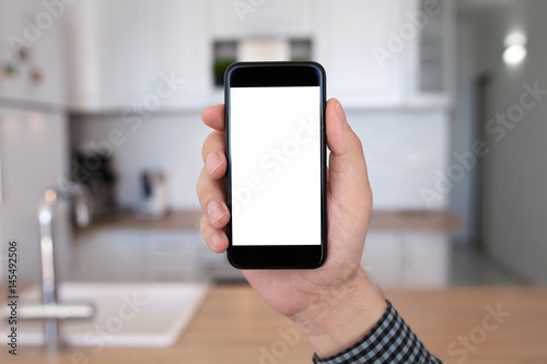 male hand holding phone with isolated screen kitchen in house