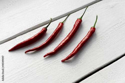 Red hot chili pepper on a wooden white background