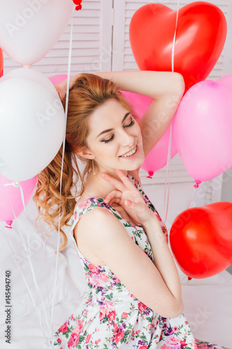 Girl in romantic dress with balloons in the shape of a heart
