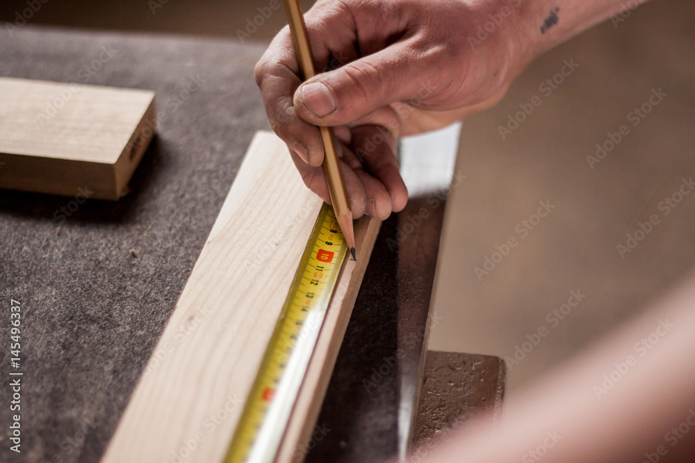 carpenter painting a line for cutting wood