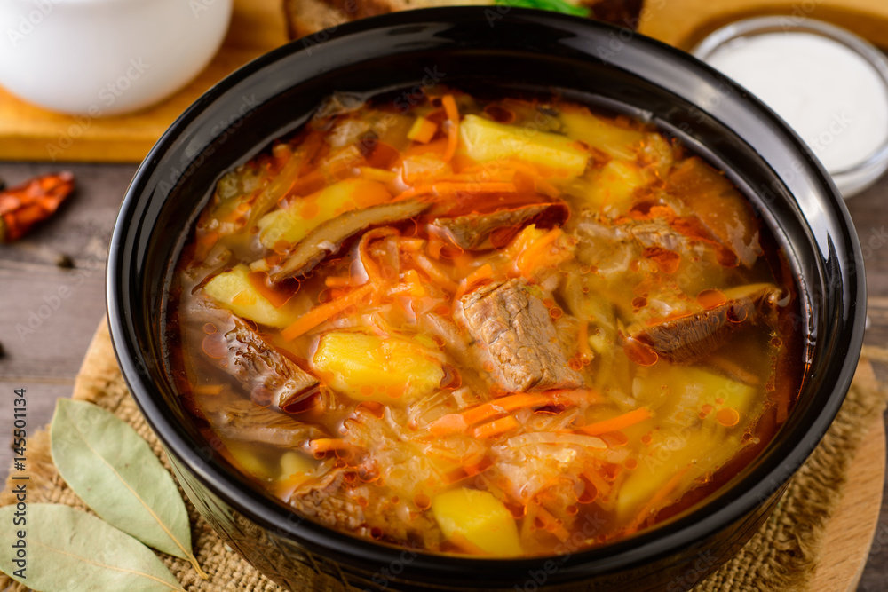 Shchi - traditional russian cabbage soup on wooden table. Shchi - traditional russian cabbage soup on wooden table.