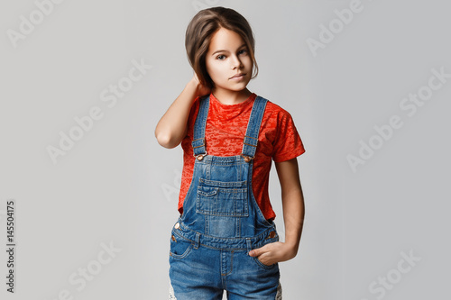 фотографія Beautiful teen girl with thick shiny hair and perfect skin on a gray background