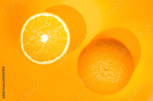 Two oranges on orange background. Art food concept