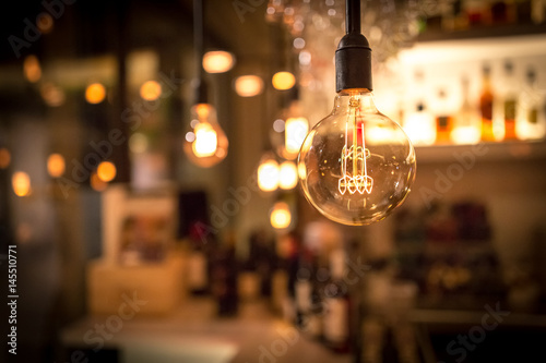 Vintage lamp bulb with bar or cafe night abstract background photo