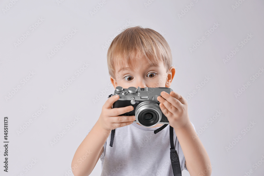 Cute boy with film camera on light background Cute boy with film camera on light background