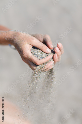 Young woman with sand in hands