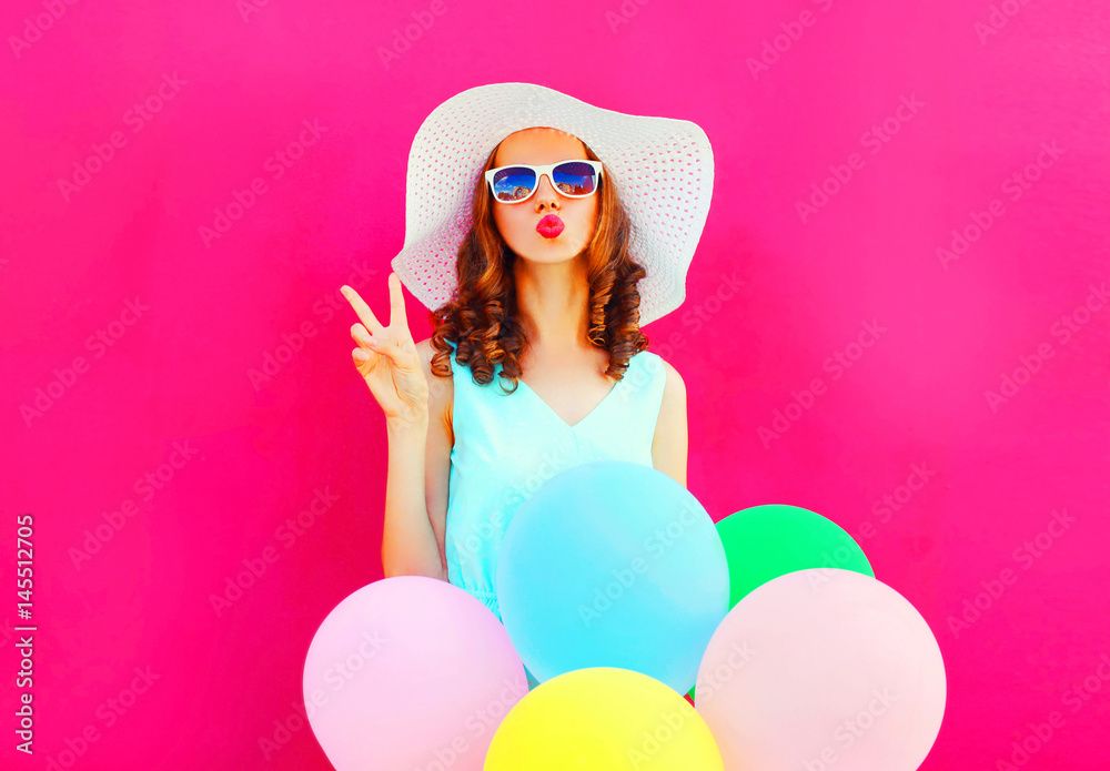 Fashion woman blowing lips holds an air colorful balloons on a pink background Fashion woman blowing lips holds an air colorful balloons on a pink background