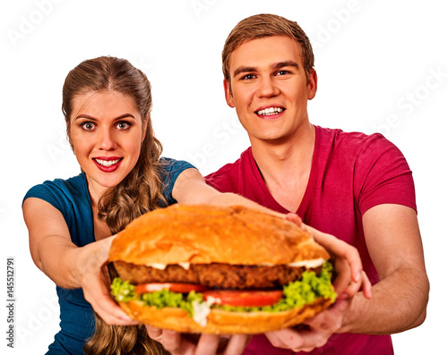 Couple eating fast food. Man and woman treat big hamburger with ham . Friends give burder junk on white background isolated.