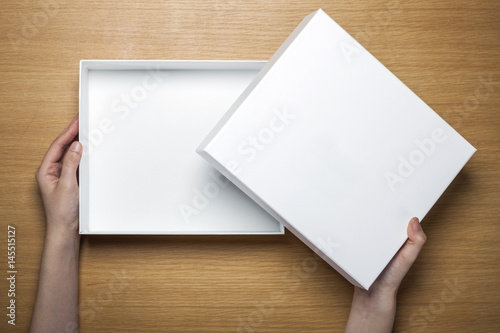 woman hand hold a paper on the wood table(background)