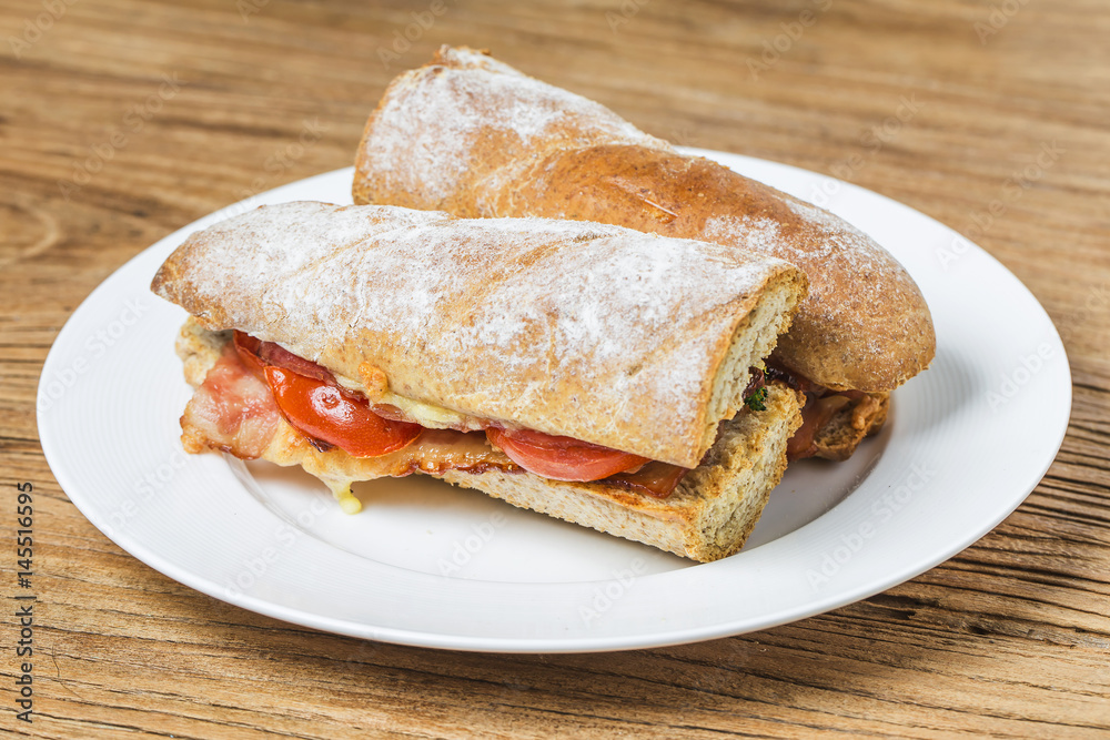 open sandwich with prosciutto, mozzarella and tomatoes on kitchen table, shallow focus open sandwich with prosciutto, mozzarella and tomatoes on kitchen table, shallow focus