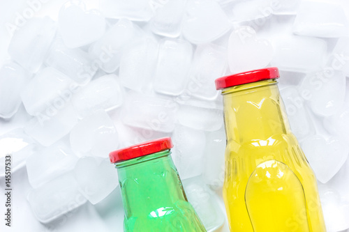 colorful plastic bottles with ice cubes white desk background top view mockup
