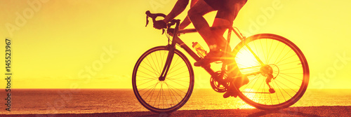 Cyclist biking on road bike sunset banner. Active healthy sports lifestyle athlete cycling.