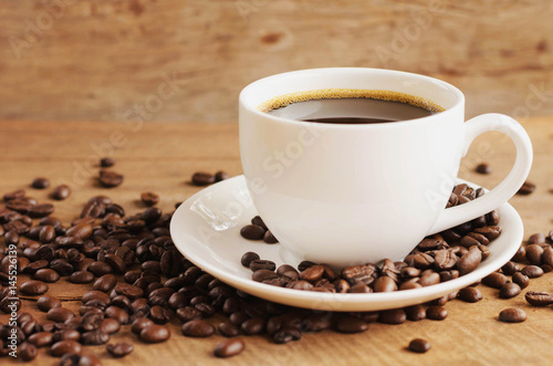 cup of coffee with beans on table background
