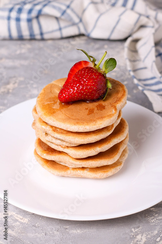 delicious healthy pancakes with strawberries on white plate