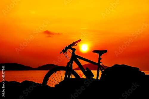 Silhouette bicycle with sea sunset in twilight