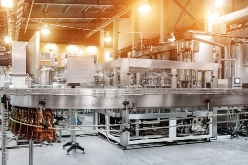 Fotografie The filling machine pours beer into plastic PET bottles.