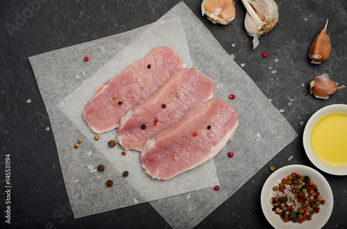 Raw fresh pork meat on black background, top view, horizontal