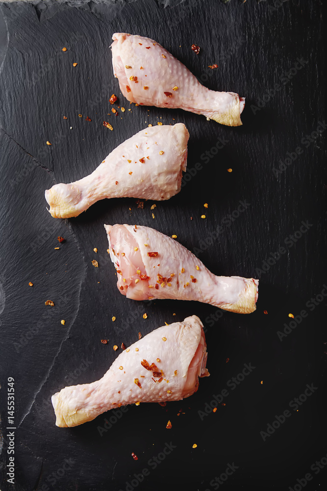 Chicken legs on a black background. Lunch on the grill. Top view