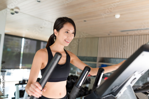 Woman training on Elliptical machine in gym