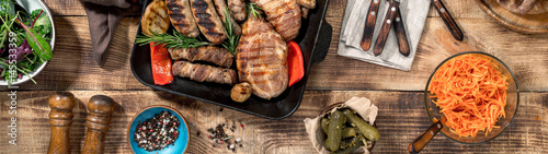 Fotografija Grilled steak, grilled sausages, grilled vegetables on the wooden table