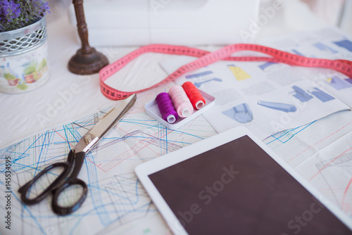Close-up of a table equipped with working things for sewing, indoors