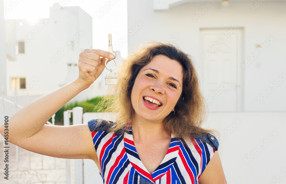 Concept of housewarming, real estate, property and moving - New home owner with key Concept of housewarming, real estate, property and moving - New home owner with key
