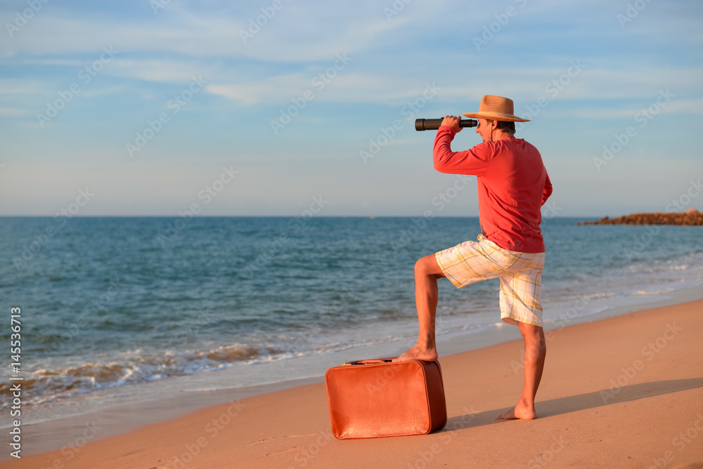 Back side view of man standing holding spyglass looking at natural ocean water shore outdoors background. Traveler discovering journey, exploring escape or market opportunities. Sunny blue sky horizon