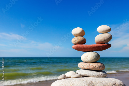 Stones balance on the background of sea and blue sky