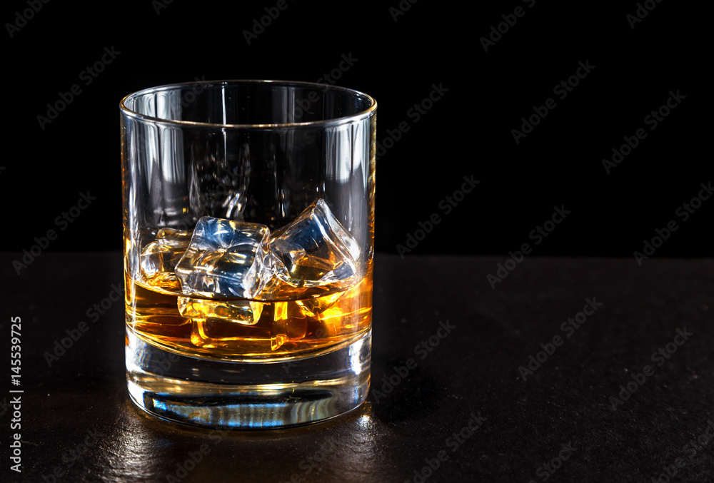 glass of whiskey with ice on a dark background