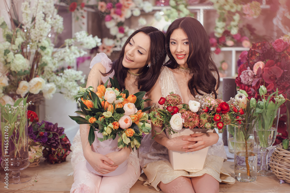 Beautiful asian women florists with bouquet of flowers in flower store
